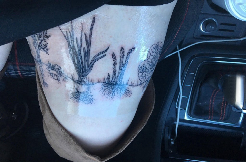 点击大图看下一张：植物纹身  女生大腿上黑灰的植物纹身图片
