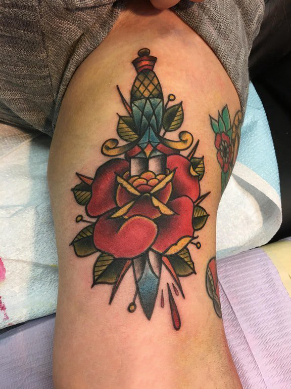点击大图看下一张：玫瑰匕首纹身  女生大臂上玫瑰和匕首纹身图片