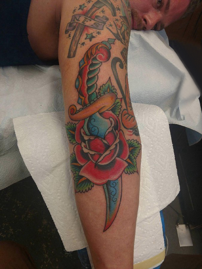 点击大图看下一张：玫瑰匕首纹身  男生手臂上彩绘的玫瑰匕首纹身图片