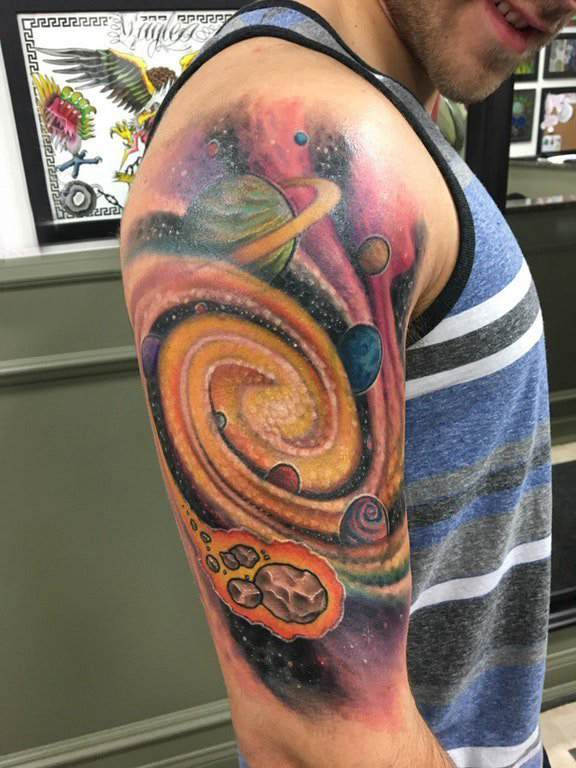 点击大图看下一张：纹身星球 男生大臂上宇宙中的星球纹身图片