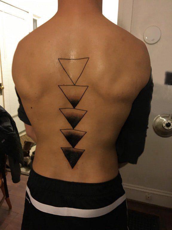 点击大图看下一张：后背纹身男 男生后背上黑色的三角形纹身图片