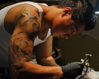点击大图看下一张：纹身师电影  人物手臂上黑灰色的龙纹身图片