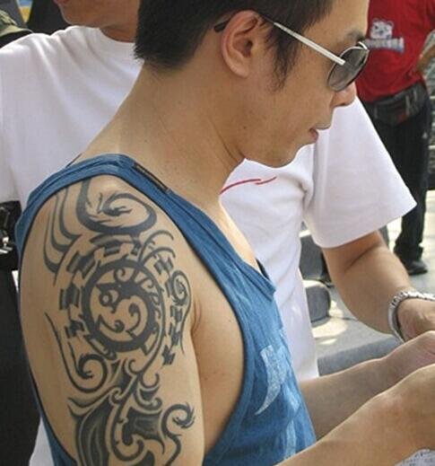 点击大图看下一张：中国纹身明星  黄贯中手臂上黑色的部落图腾纹身图片
