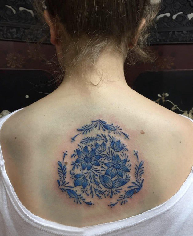 点击大图看下一张：后背纹身女 女生后背上蓝色的花朵纹身图片