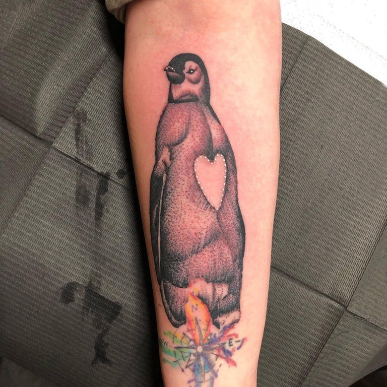 点击大图看下一张：手臂纹身素材 女生手臂上指南针和企鹅纹身图片