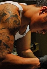 纹身师电影  人物手臂上黑灰色的龙纹身图片