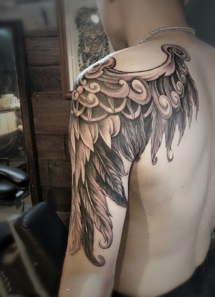 点击大图看下一张：大臂肩部的一款黑色翅膀纹身作品图案