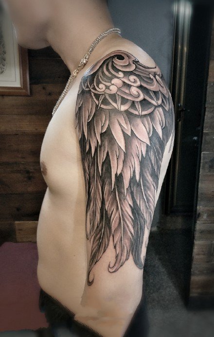 点击大图看下一张：大臂肩部的一款黑色翅膀纹身作品图案