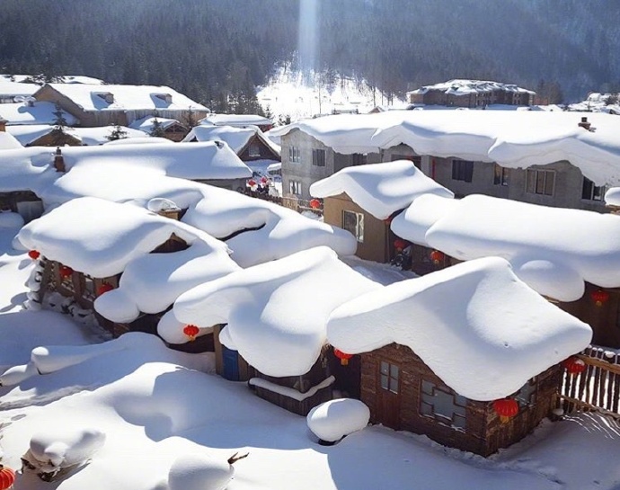 点击大图看下一张：房顶上全是白雪皑皑的雪乡美景图片欣赏