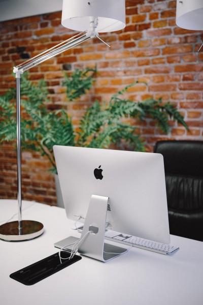 点击大图看下一张:放着台式苹果电脑的办公室图片