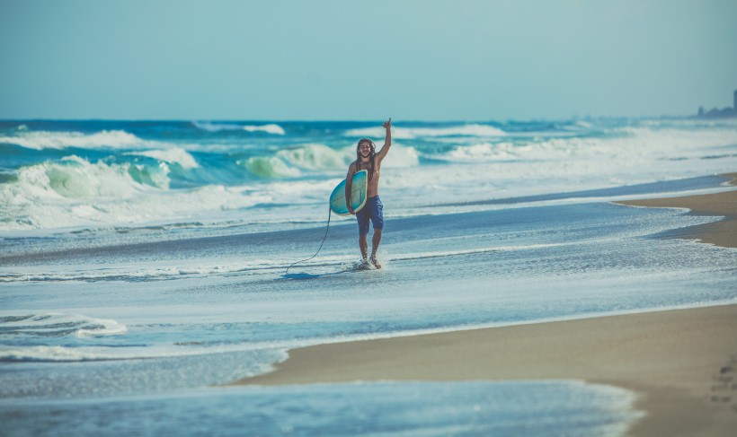 点击大图看下一张：海边拿着冲浪板的人图片