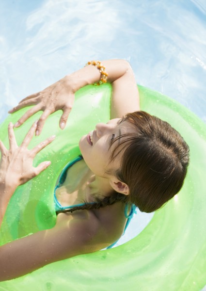 点击大图看下一张:泳池边带泳圈的美女图片