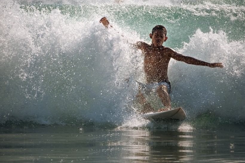 点击大图看下一张：海上冲浪的少年图片