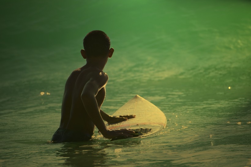 点击大图看下一张：海上冲浪的少年图片