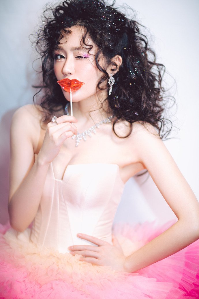 点击大图看下一张：汤晶媚一身芭比粉搭配复古泡面头，神似洋娃娃的造型