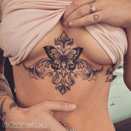 点击大图看下一张：女性胸下的性感梵花纹身作品图案
