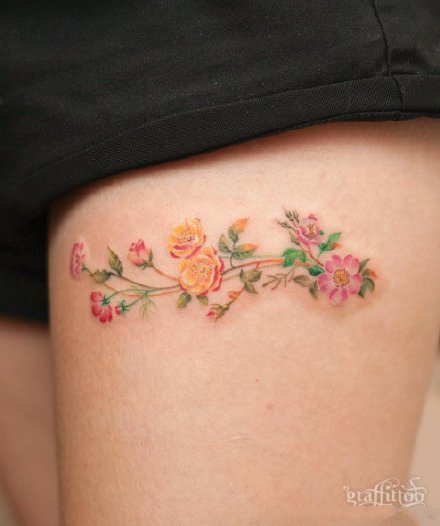 点击大图看下一张：女孩子大腿处一组小花花纹身图片