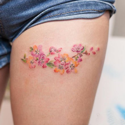 点击大图看下一张：女孩子大腿处一组小花花纹身图片
