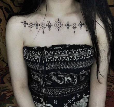 点击大图看下一张：女生胸前锁骨处的一组黑灰漂亮纹身图片