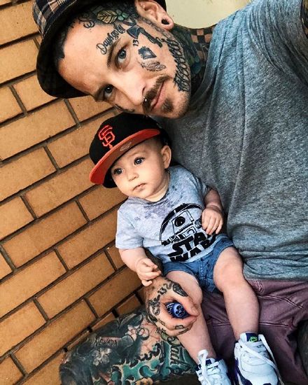 点击大图看下一张：抱着的孩子纹身型男父爱主题照片