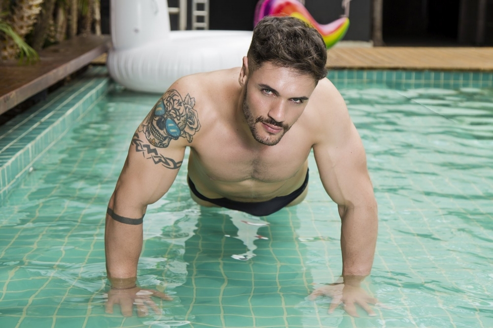 点击大图看下一张：身穿三角泳裤的欧美肌肉帅哥泳池边性感写真