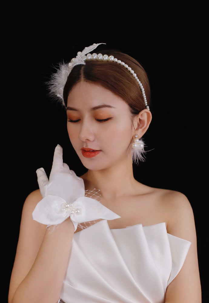 点击大图看下一张：羽毛和珍珠点缀的甜美复古新娘发型