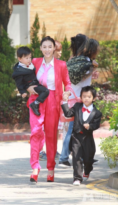 点击大图看下一张：张柏芝携儿子喜气红套装参加弟弟婚礼(2)
