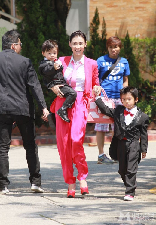 点击大图看下一张：张柏芝携儿子喜气红套装参加弟弟婚礼(4)