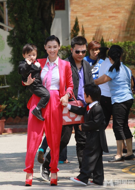点击大图看下一张：张柏芝携儿子喜气红套装参加弟弟婚礼(7)