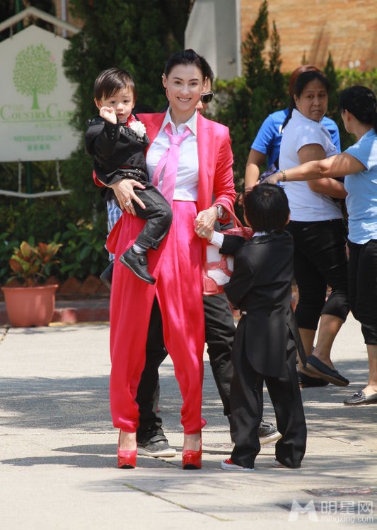 点击大图看下一张：张柏芝携儿子喜气红套装参加弟弟婚礼(6)