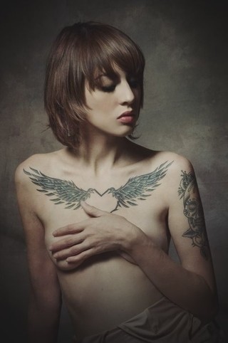 点击大图看下一张：女性胸前羽翼刺青
