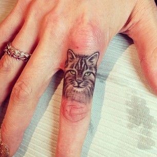 点击大图看下一张：手指小小的猫头像纹身