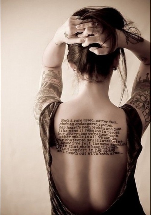 点击大图看下一张：女性背部的字符刺青。