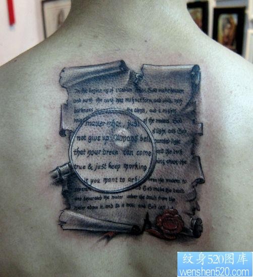 点击大图看下一张：背部经典的书卷字母纹身图片