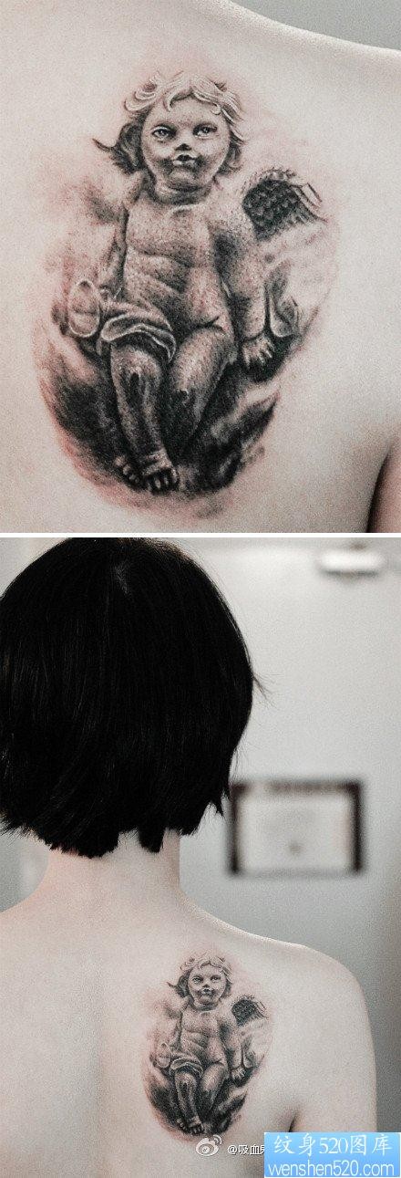 点击大图看下一张：女人肩背一张呆呆的丘比特纹身图片