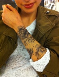 手臂上一款淡色的花朵纹身