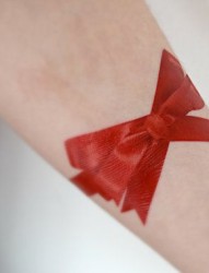 欧美女生手臂上大红的蝴蝶结纹身