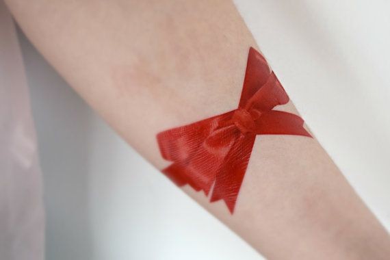 点击大图看下一张：欧美女生手臂上大红的蝴蝶结纹身
