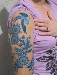 女性大臂上一款青花色纹身