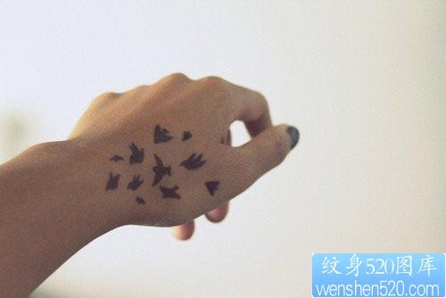点击大图看下一张：女人手部一幅图腾小鸟纹身图片