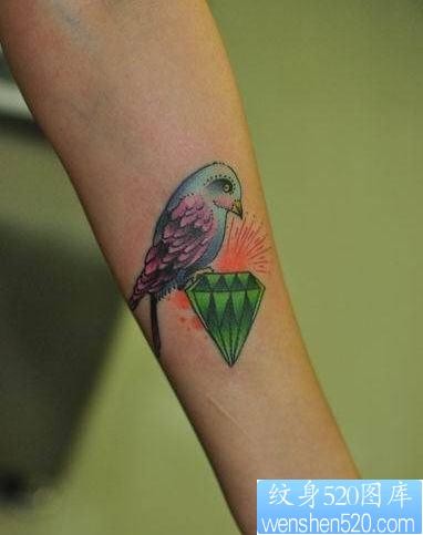 点击大图看下一张：女人手臂一幅彩色小鸟与钻石纹身图片