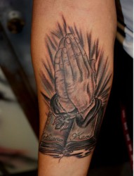 大臂上一组老人祈祷手纹身作品