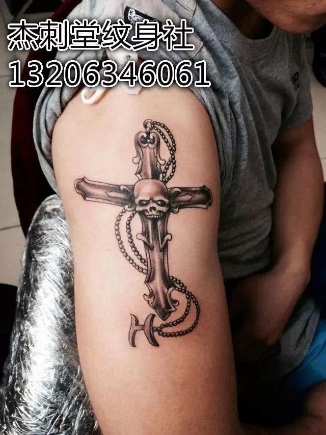 点击大图看下一张：大臂上帅气的十字架骷髅纹身