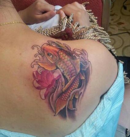 点击大图看下一张：一张女孩子肩背彩色小鲤鱼莲花纹身图片