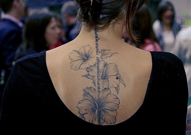 点击大图看下一张：女性背部淡墨色花朵英文纹身