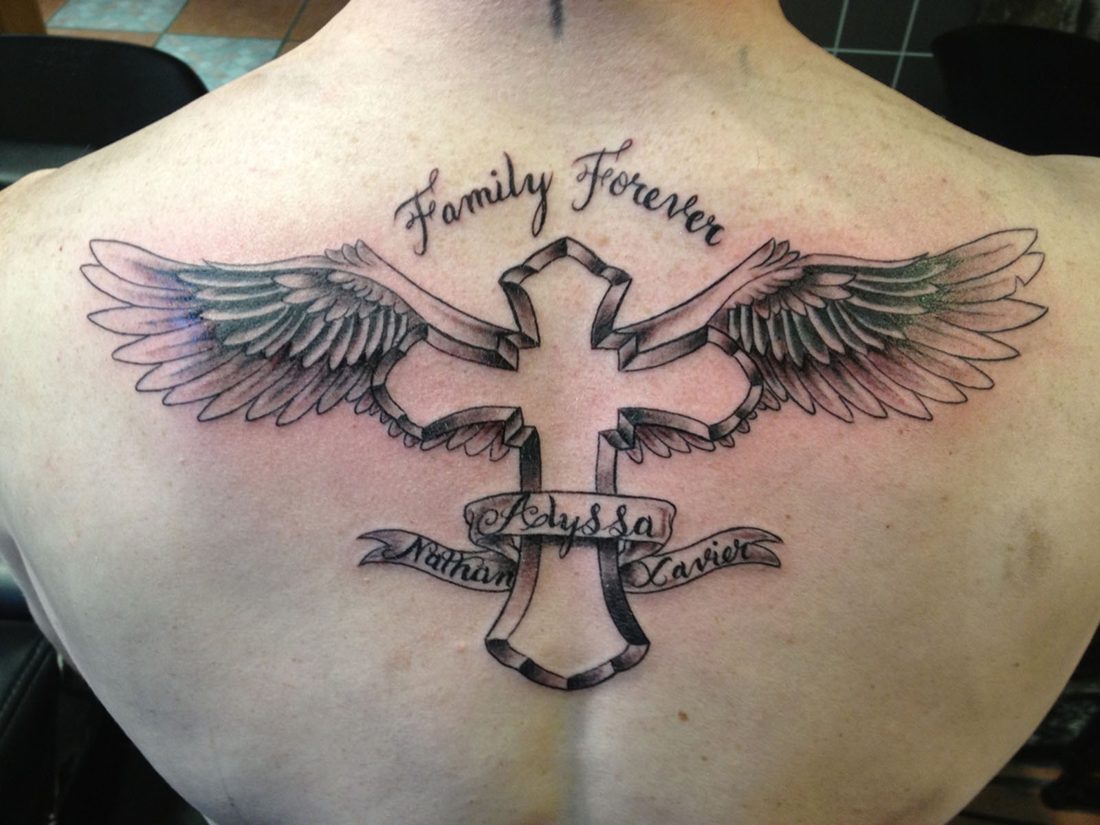 点击大图看下一张：背部经典的十字架翅膀英文纹身