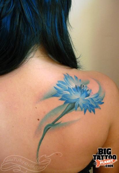 点击大图看下一张：女性肩部好看的蓝色花朵纹身