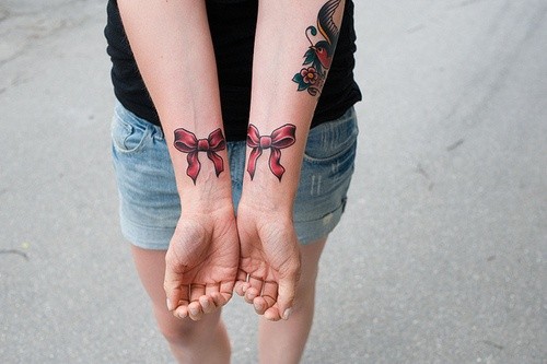点击大图看下一张：女生手腕红色蝴蝶结纹身