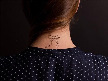 点击大图看下一张：颈部小巧的蝴蝶结纹身