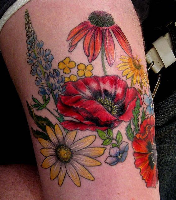点击大图看下一张：大腿部鲜艳的花朵纹身